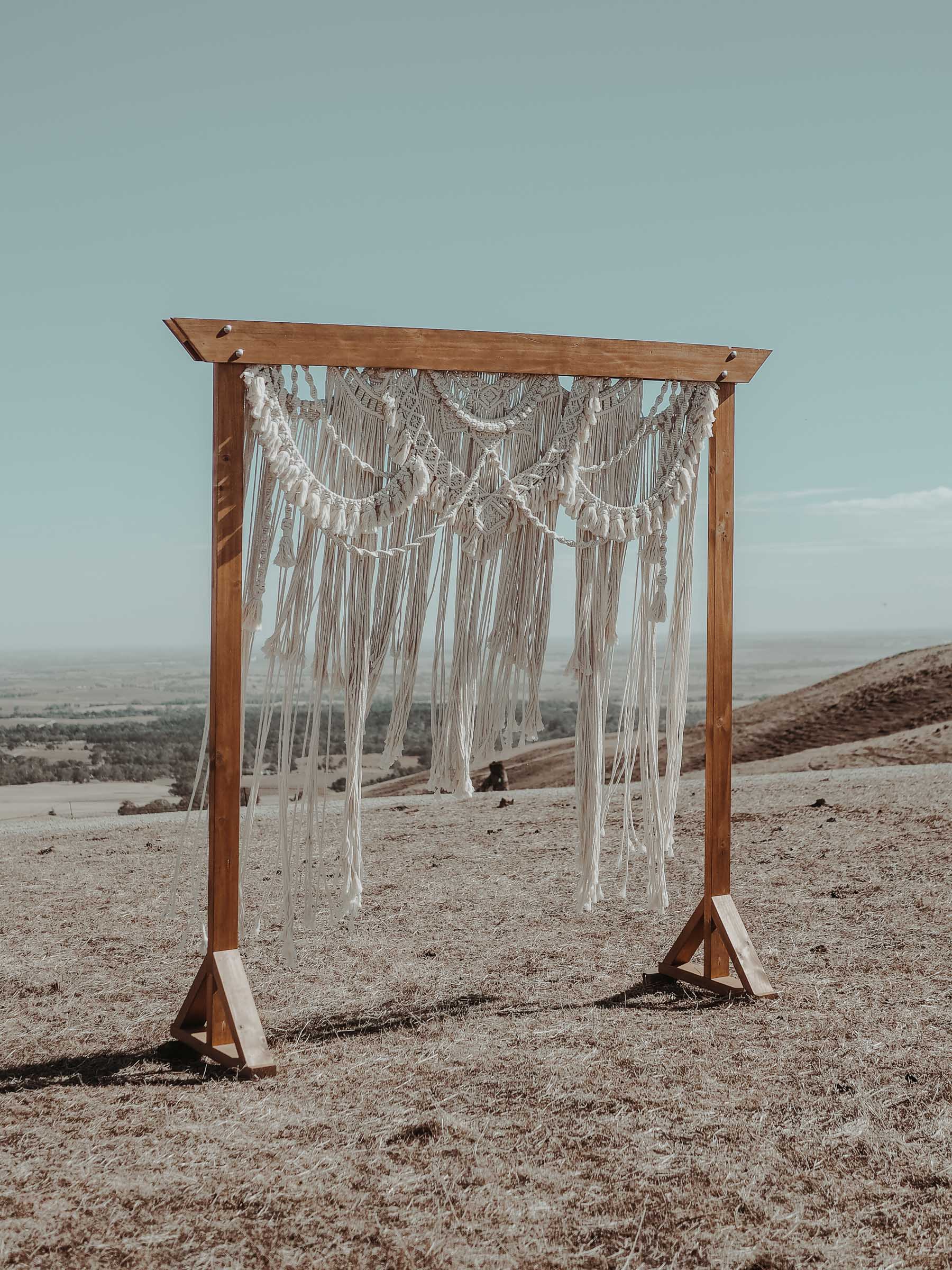 Rustic wooden arbour with a handmade macrame backdrop