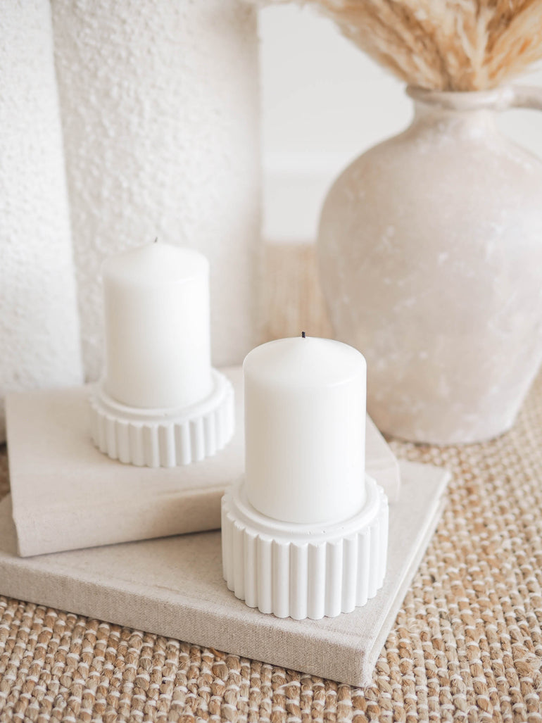 Preston candle holders in small and large size displayed on a stack of books