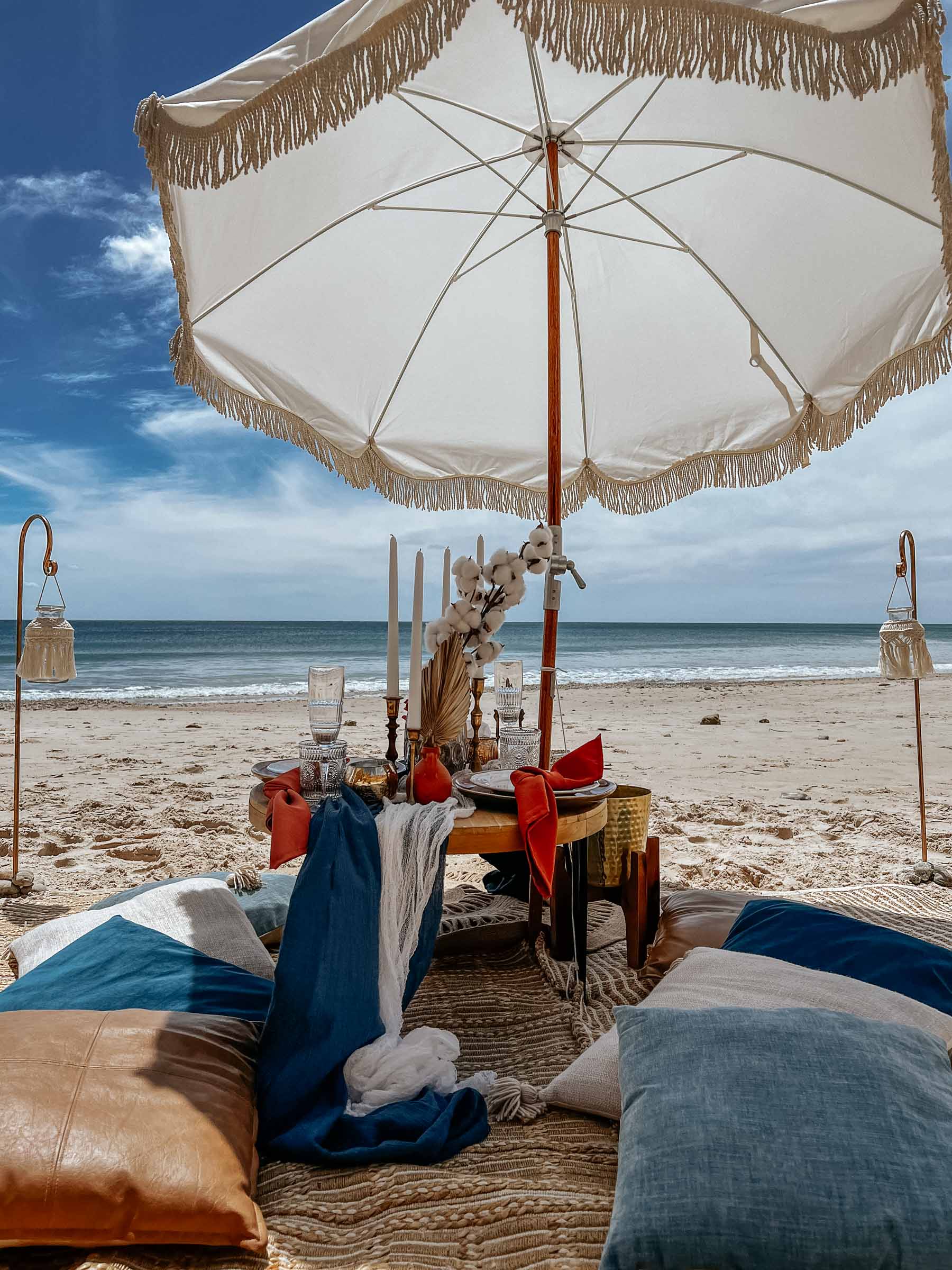 Boho beach picnic proposal with a beach umbrella