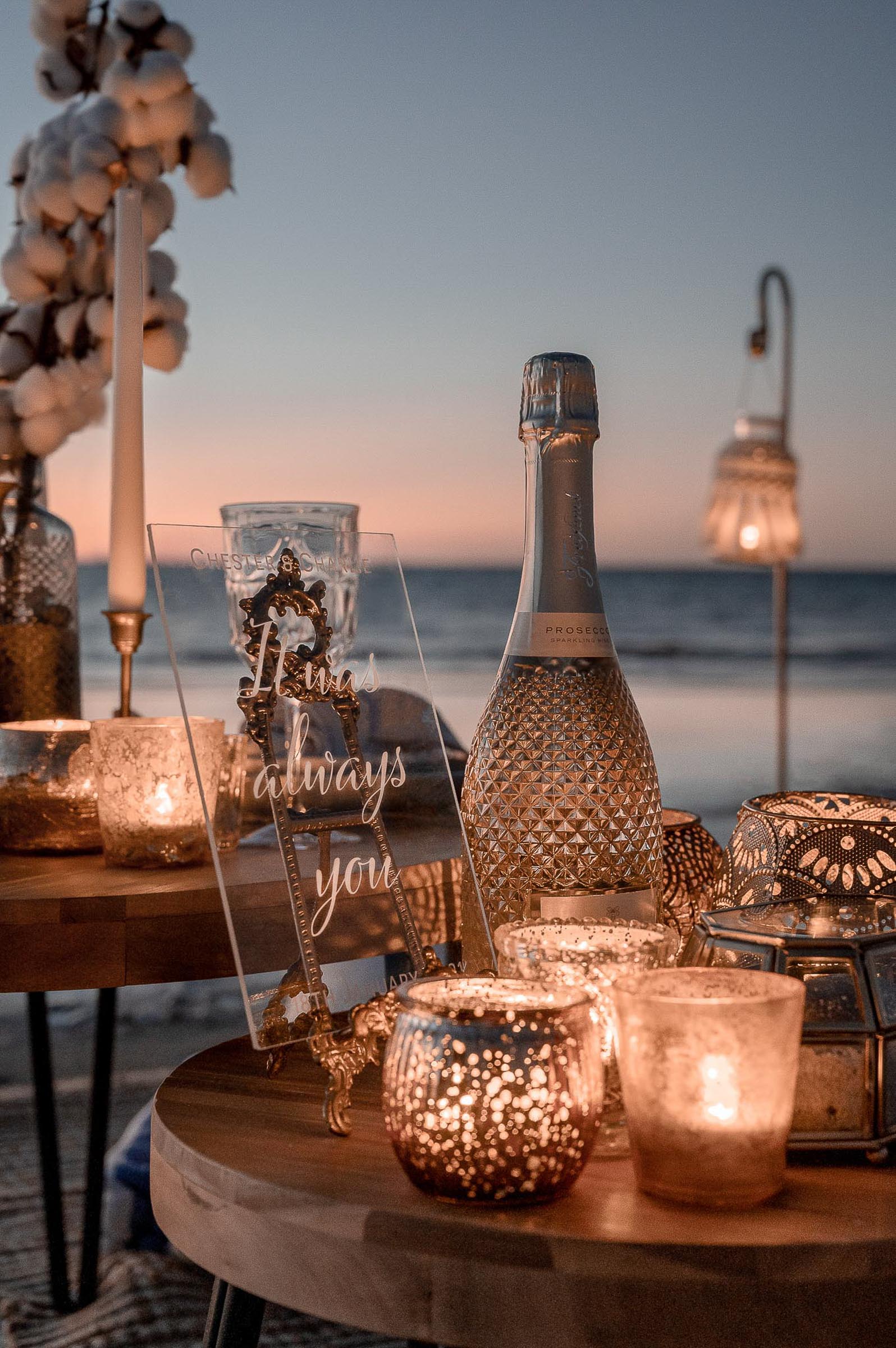 Surprise beach picnic proposal at sunset - close up of candle holders and table settings - Photography credits: Nargis Rahimi