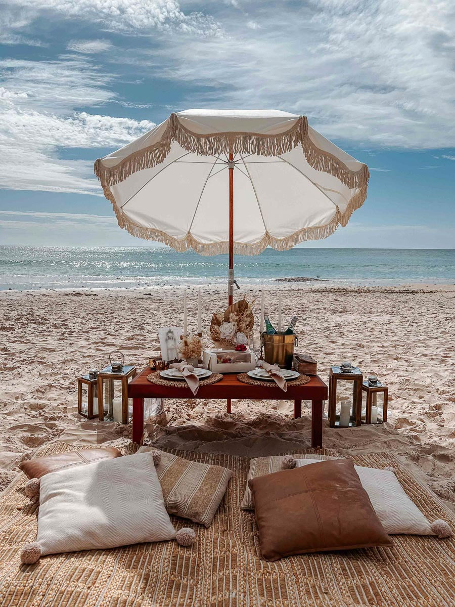 Boho beach picnic - details of table with dried floral arrangements, gold ice bucket, grazing box