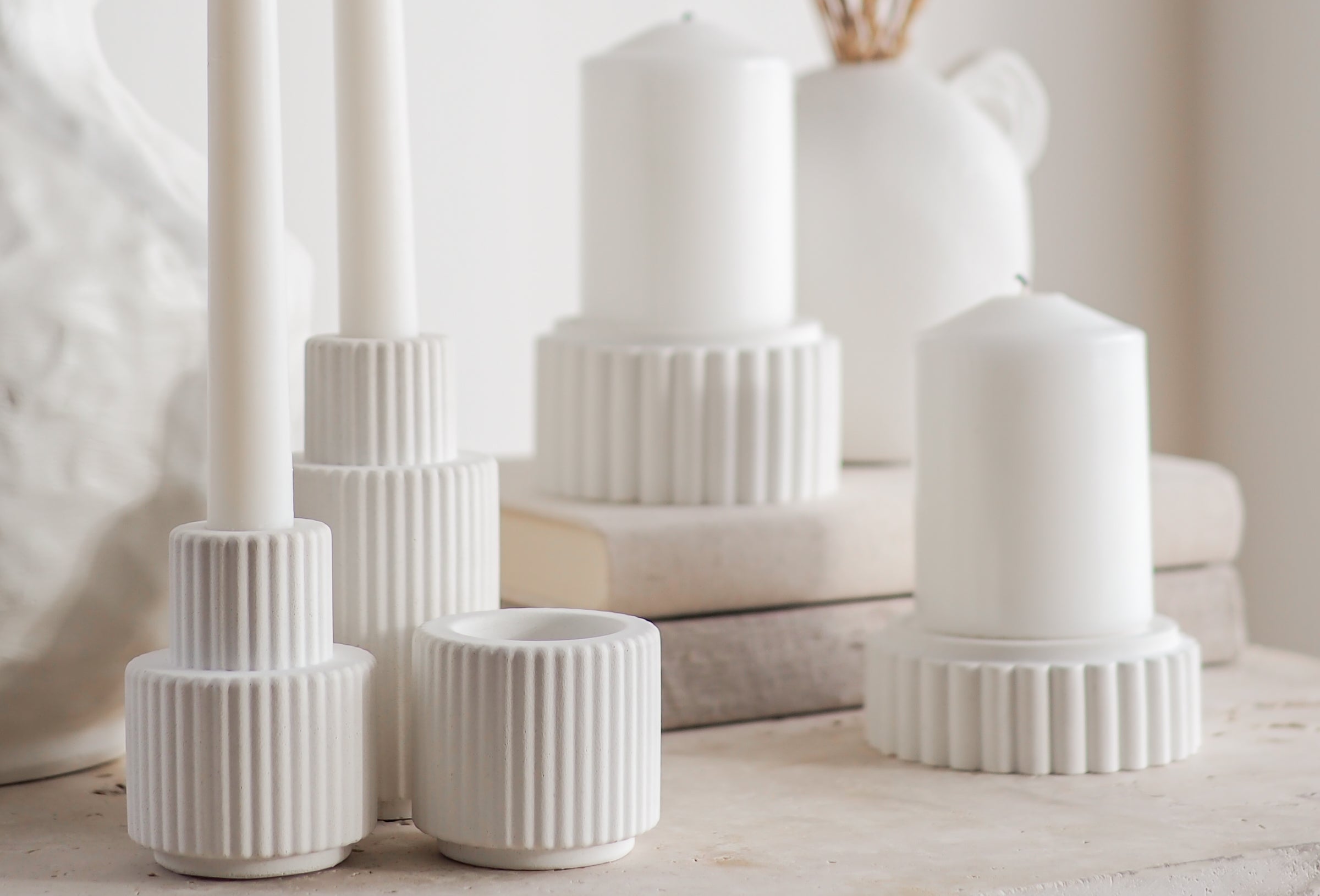 Palmer and Preston concrete candle holders displayed on a travertine table