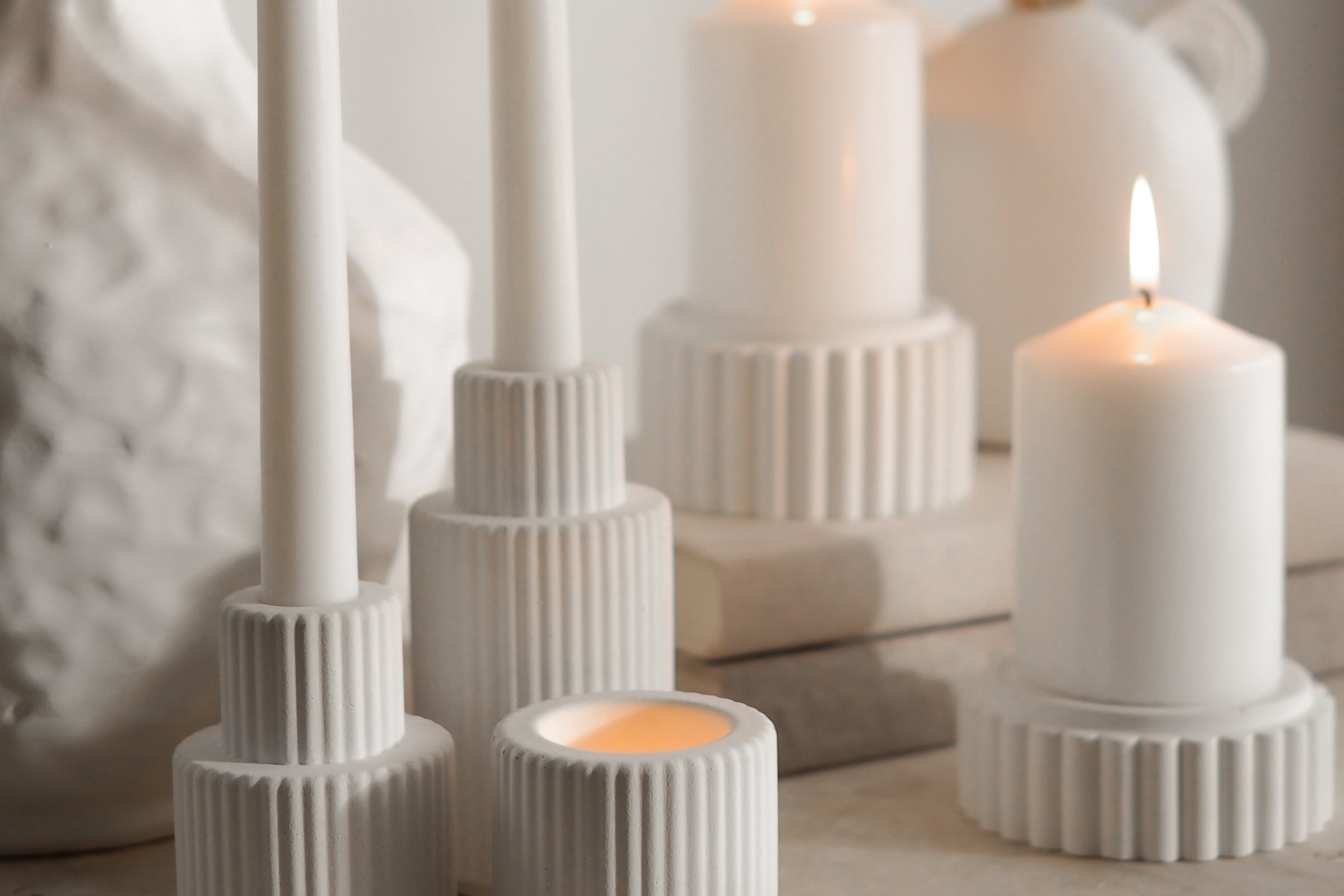 Palmer and Preston candles displayed with lit candles that cast lovely romantic shadows on the travertine table