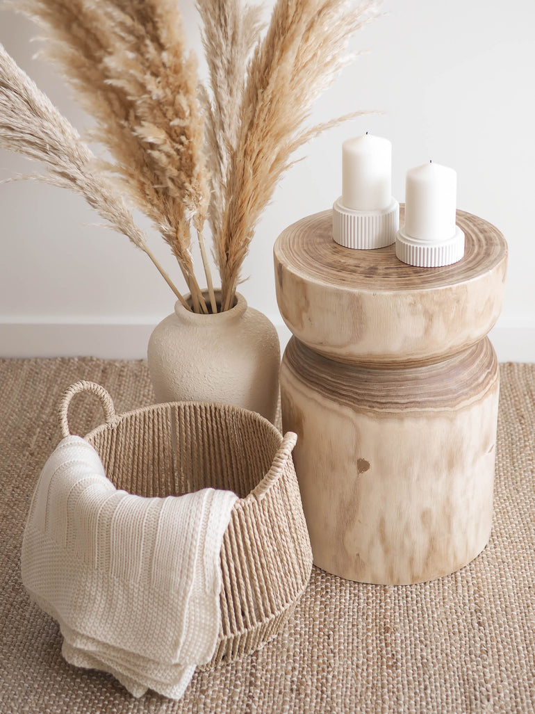 Large and small Mason candle holders displayed with a large vase full of pampas and a basket with a cream coloured throw