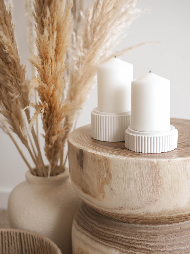 Mason small and large pillar candle holders on a natural wood side table with pampas in the background