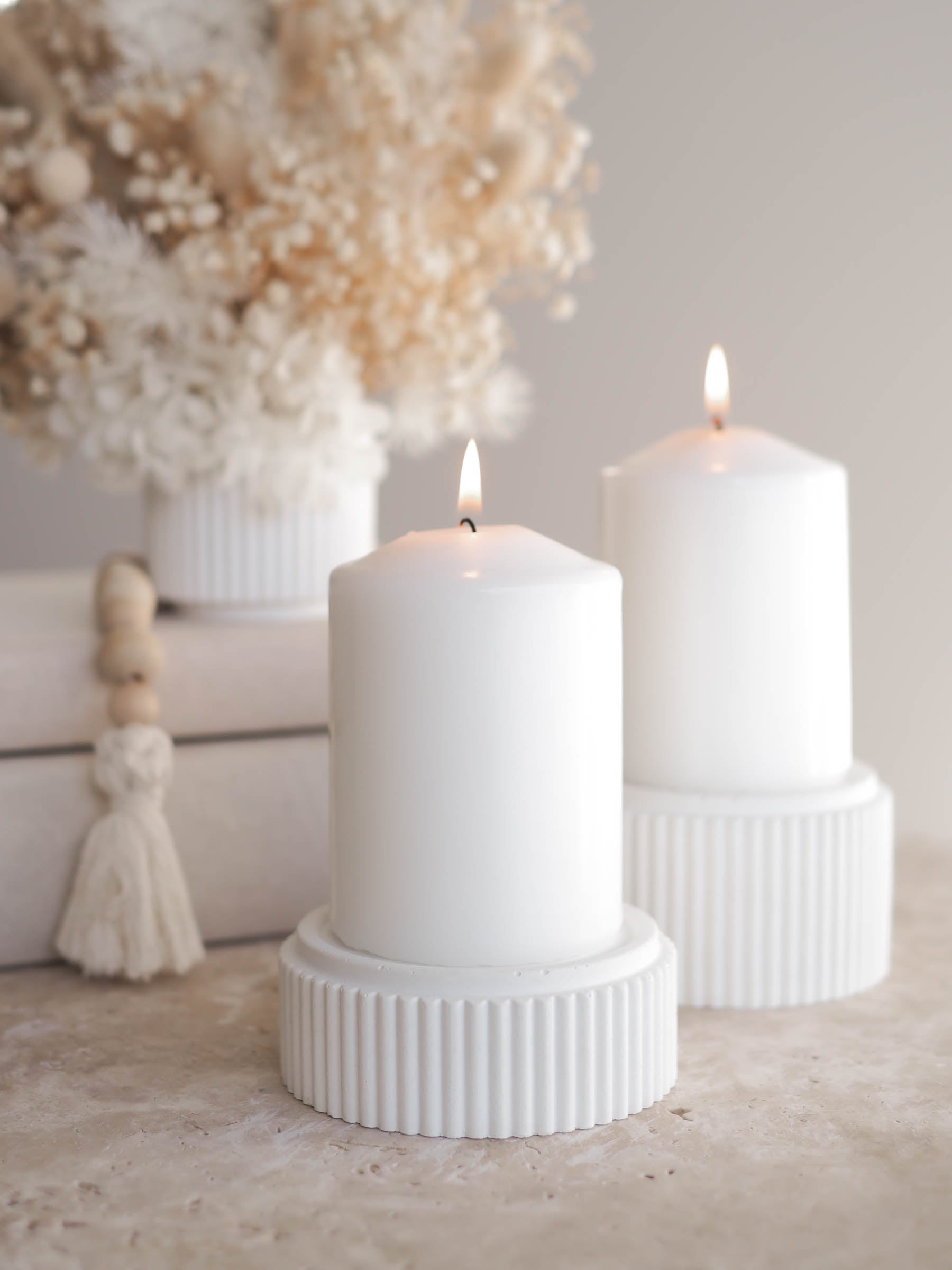 Small and large Mason candle holders with lit pillar candles on display