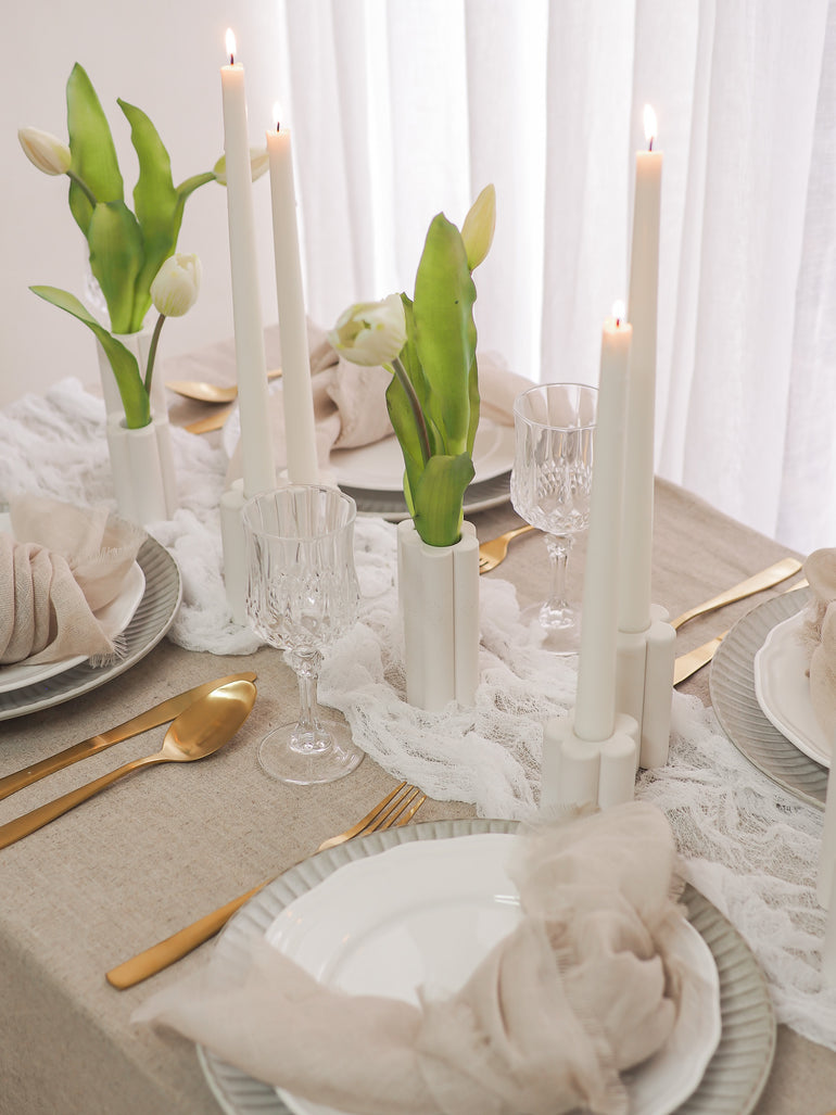 Palomino vases and Willow candle holders with tulips on a wedding table with gold cutlery and soft neutral tones