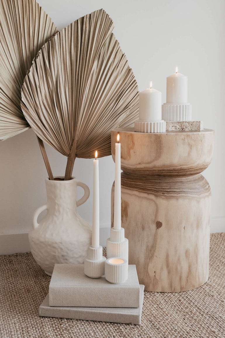 Palmer candle holder trio displayed on a stack of books next to a natural wooden side table and our Preston candle holders