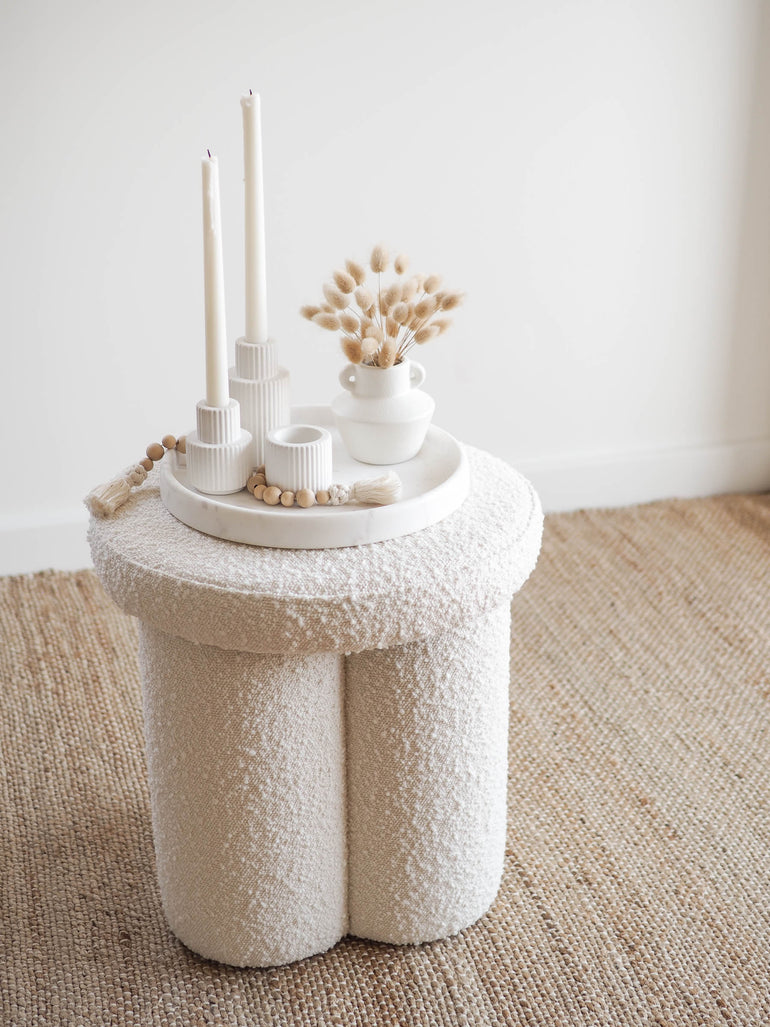 Palmer concrete candle holders displayed on a marble tray on a boucle ottoman