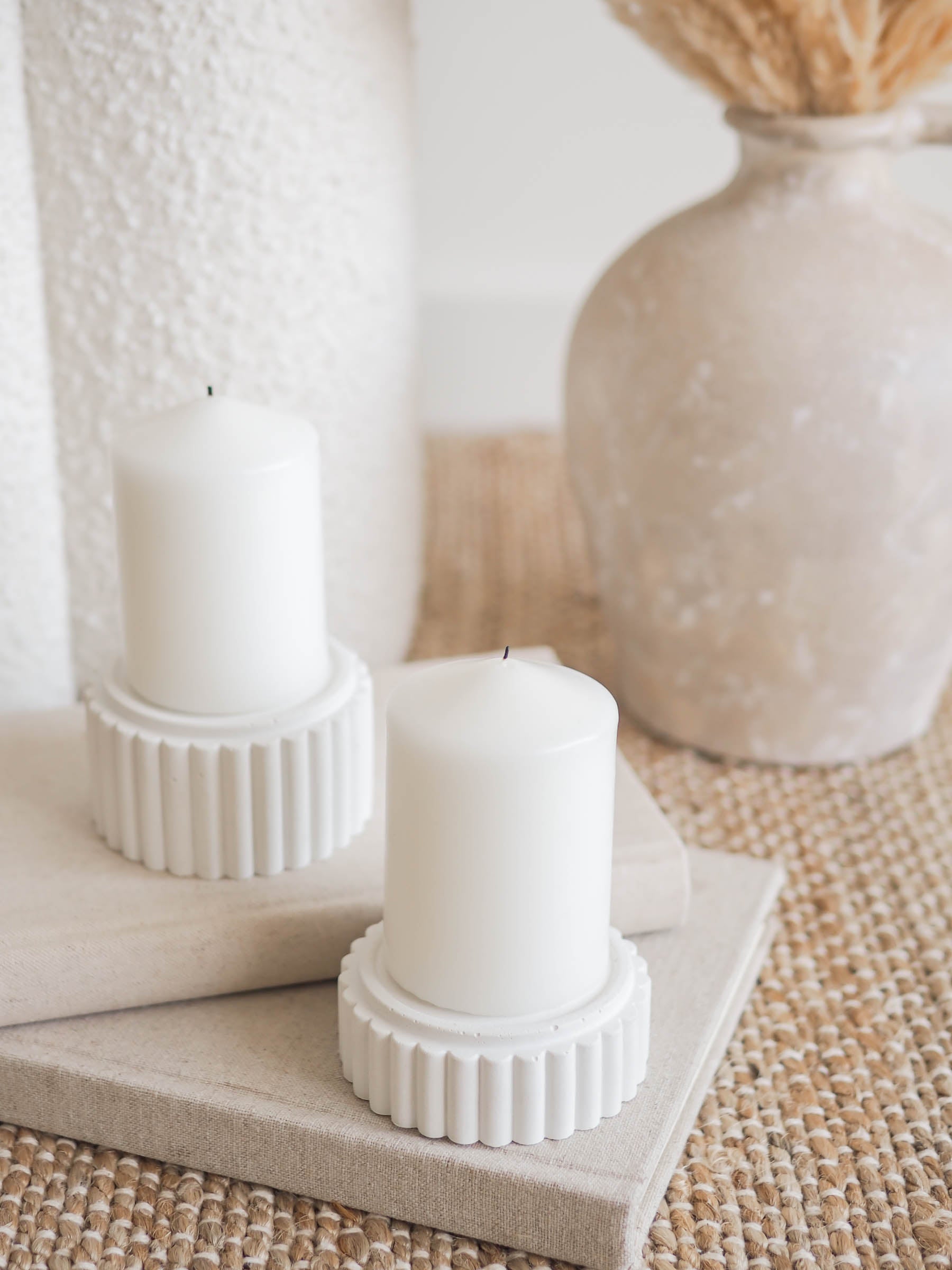 Preston small and large pillar candle holders displayed on a stack of linen books